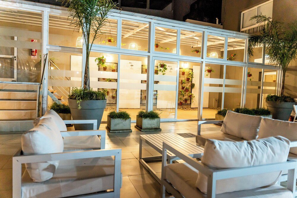 Terraza exterior con muebles blancos y plantas en macetas
