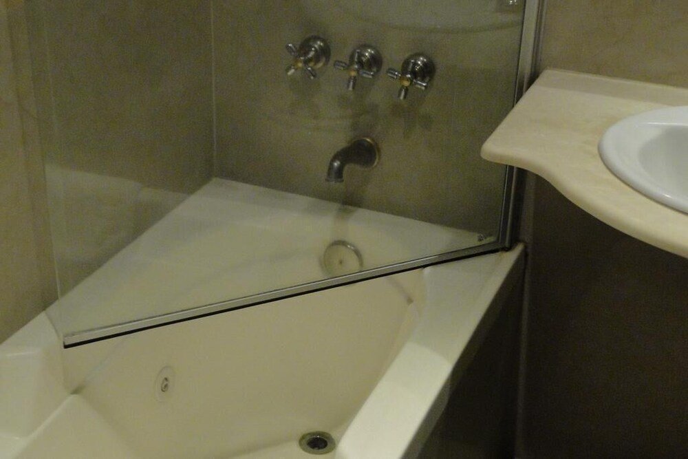 Baño moderno con ducha de vidrio, bacha blanca y mesada beige