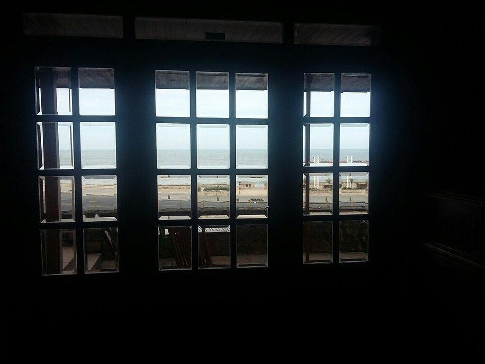 Sala con gran ventanal que da a la playa y a un puente