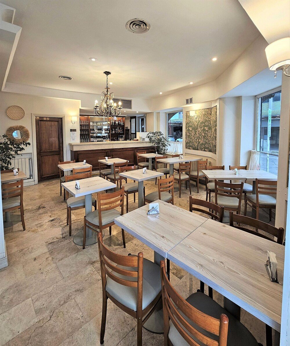 Bar del hotel con barra, mesas y sillas