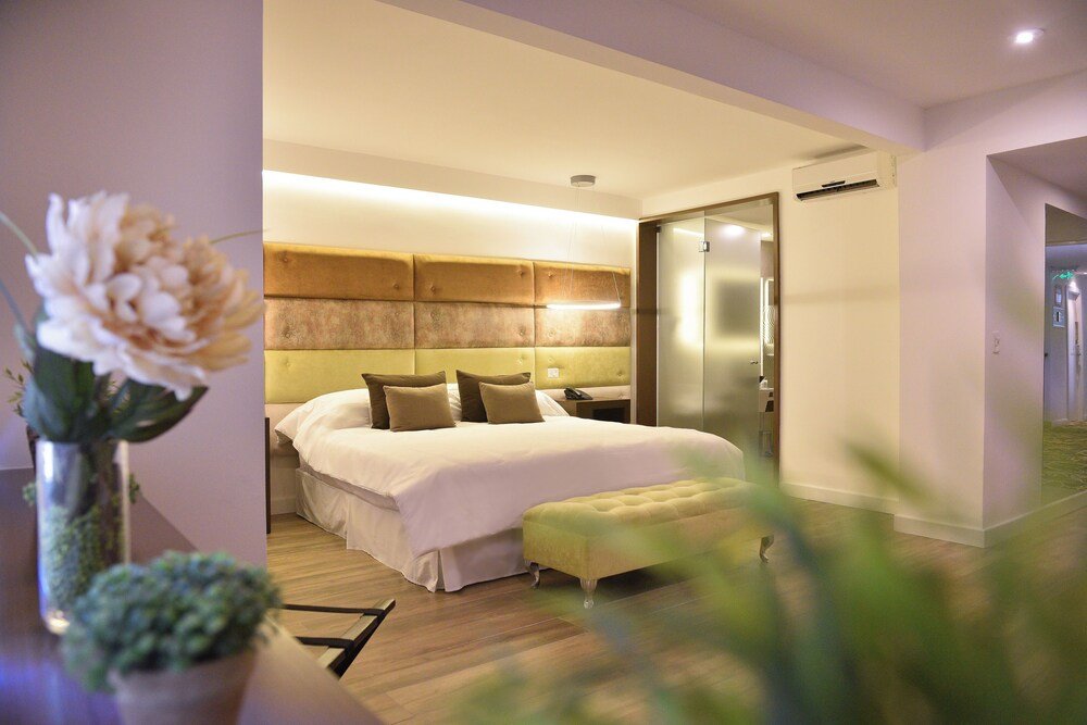 Dormitorio moderno con cama grande, mesas de luz y pared de vidrio
