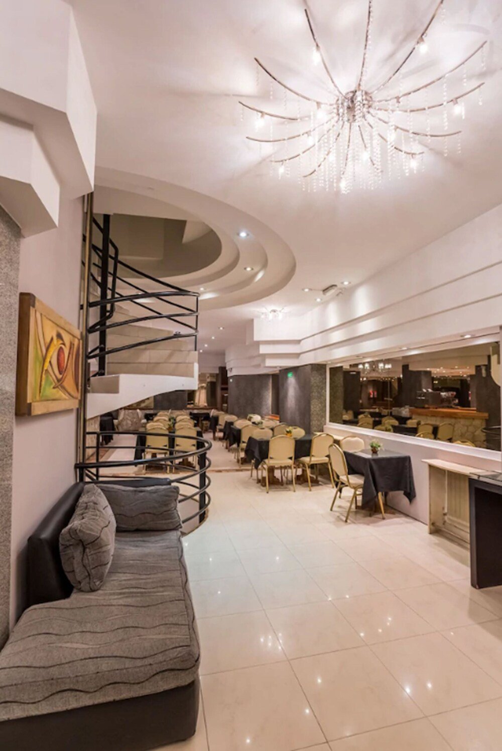 Interior moderno del hotel con escalera caracol, zona de comedor y barra