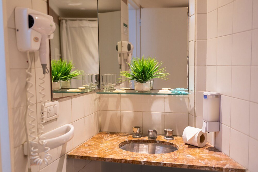 Baño con mesada de mármol, espejo y secador de pelo