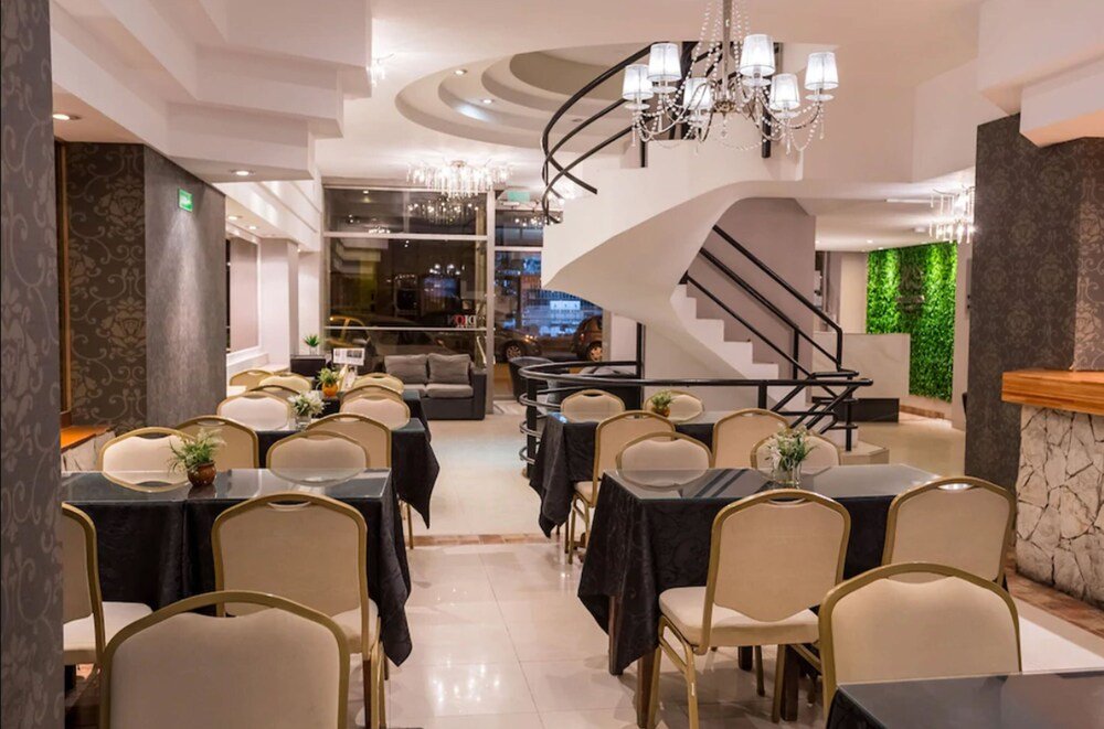 Salón comedor con mesas redondas, arañas de luz y escalera