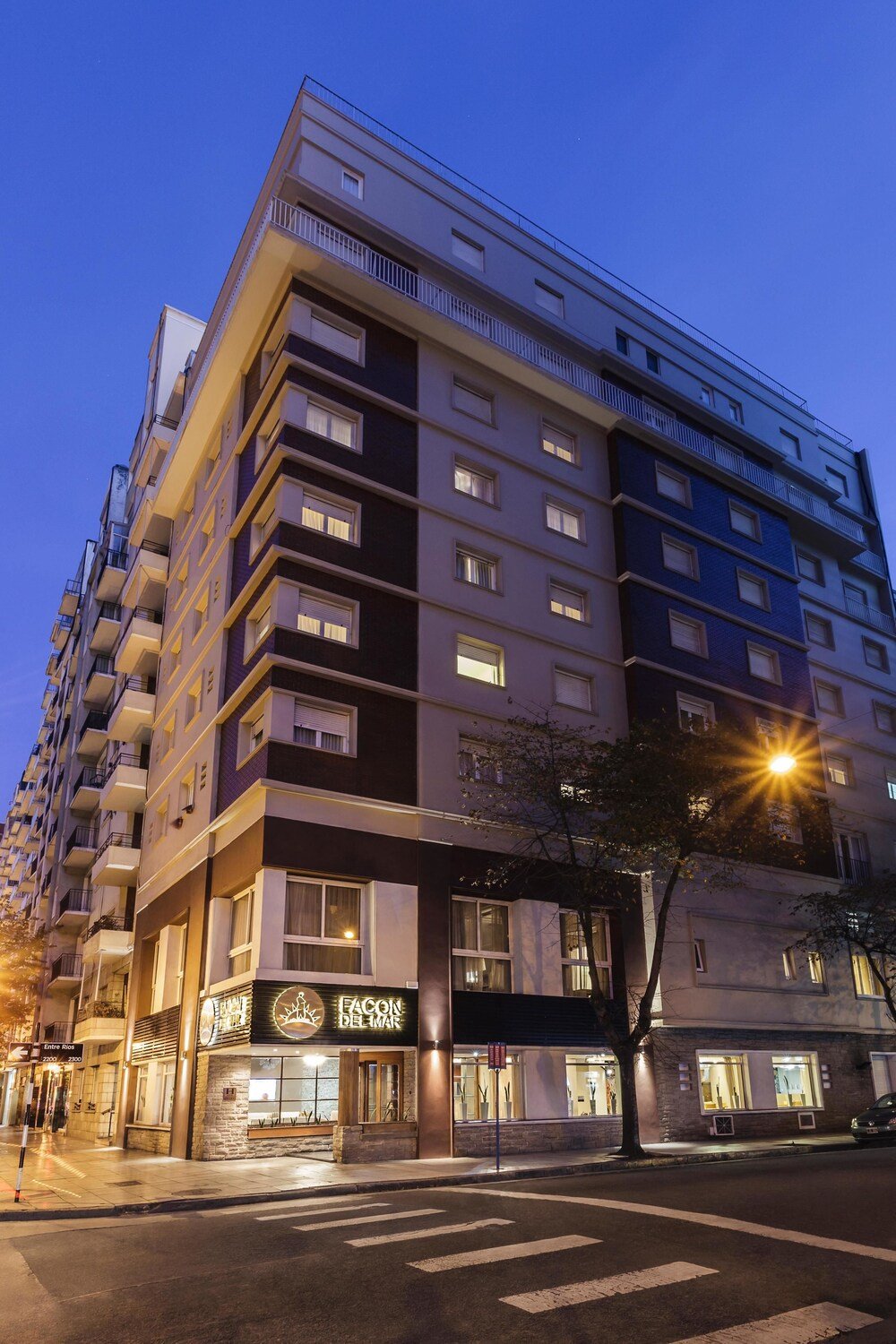 Frente del hotel de varios pisos con balcones y local en planta baja