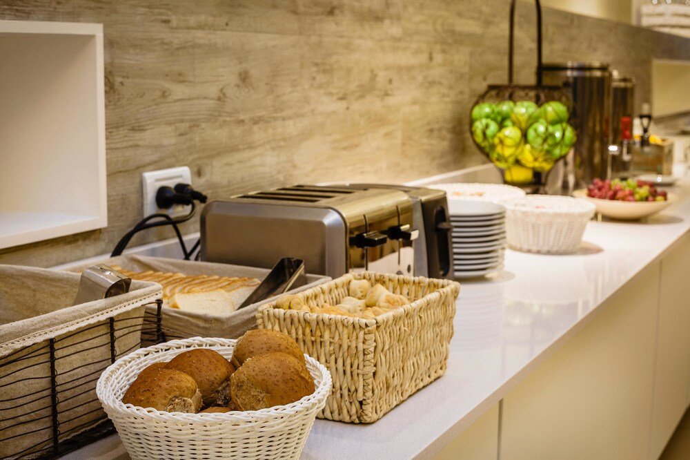 Mesa de buffet con panes, facturas y frutero