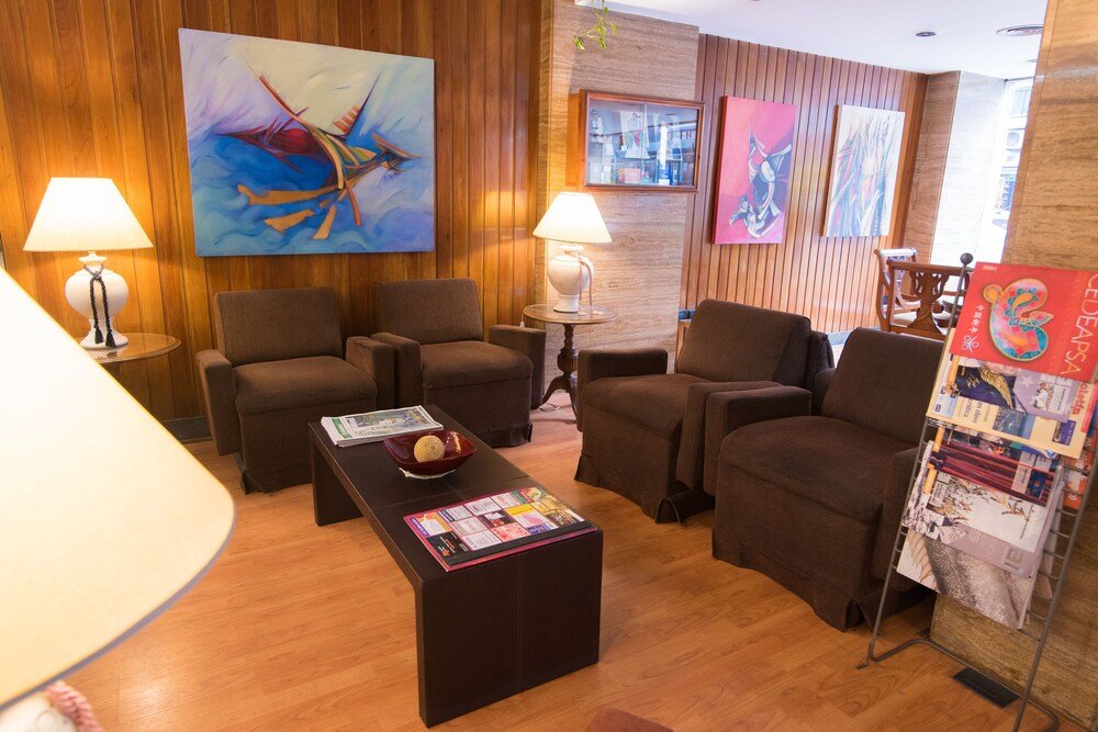 Hall moderno con paneles de madera, sillones y cuadros en las paredes