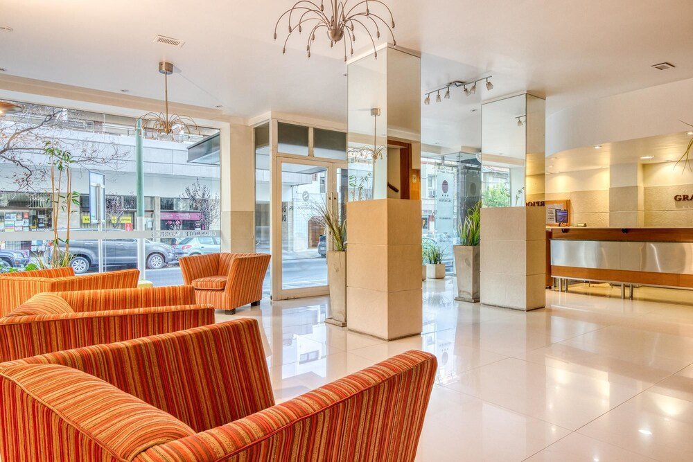 Hall moderno con sillones a rayas, recepción y ventanales a la calle