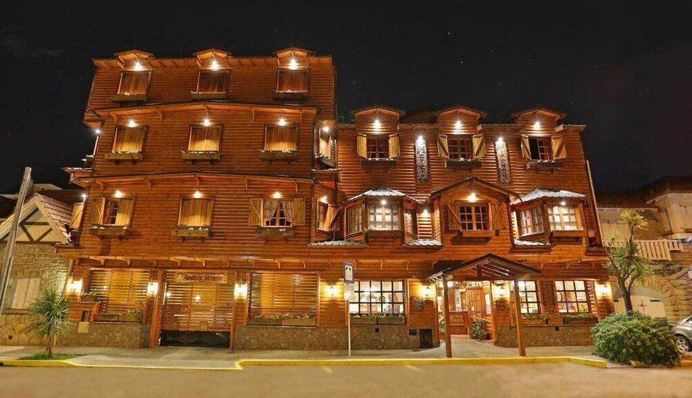 Edificio de madera de varios pisos con balcones y ventanas iluminadas