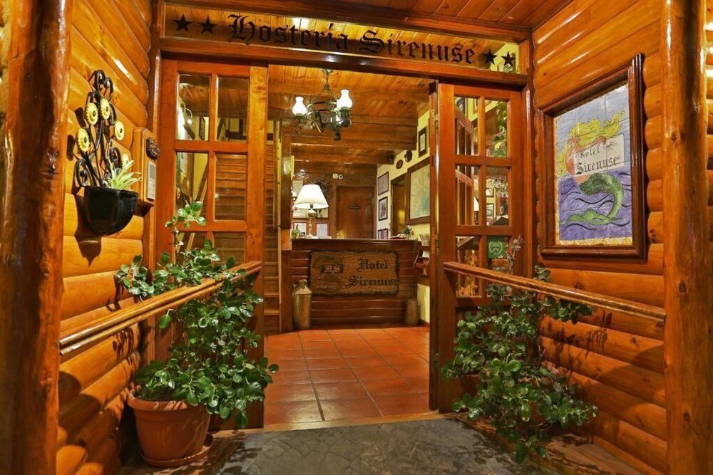 Interior estilo cabaña de madera con el cartel de la hostería