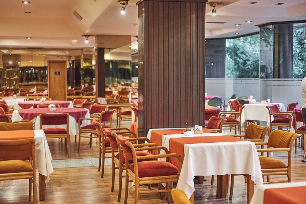 Restaurante con mesas, sillas y piso de madera con luz natural