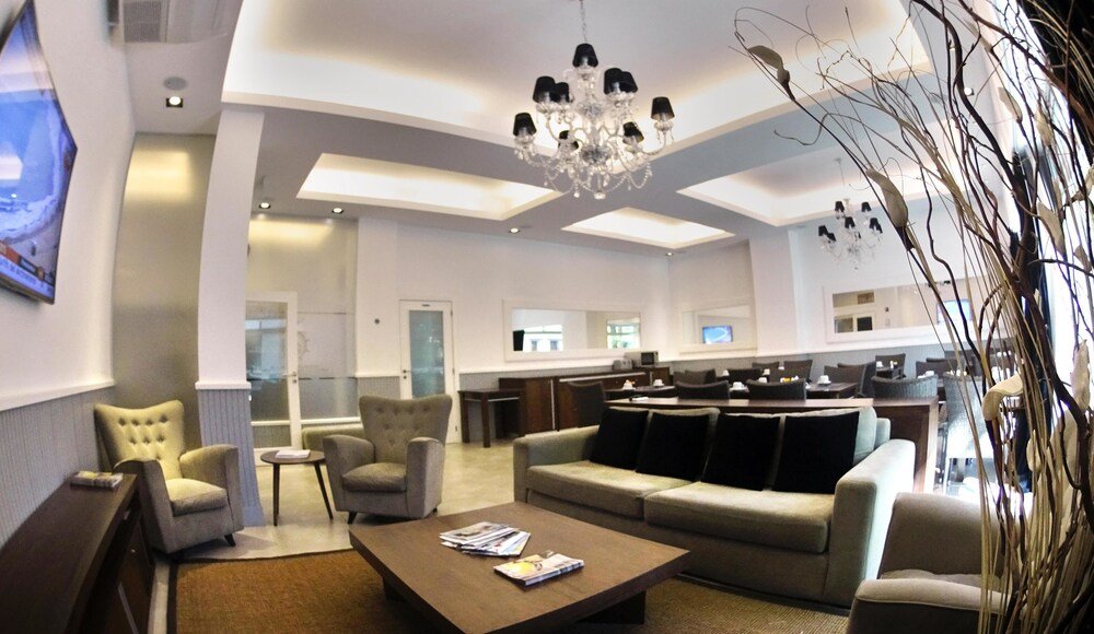 Sala de estar del hotel con sillón, butacas y mesa ratona