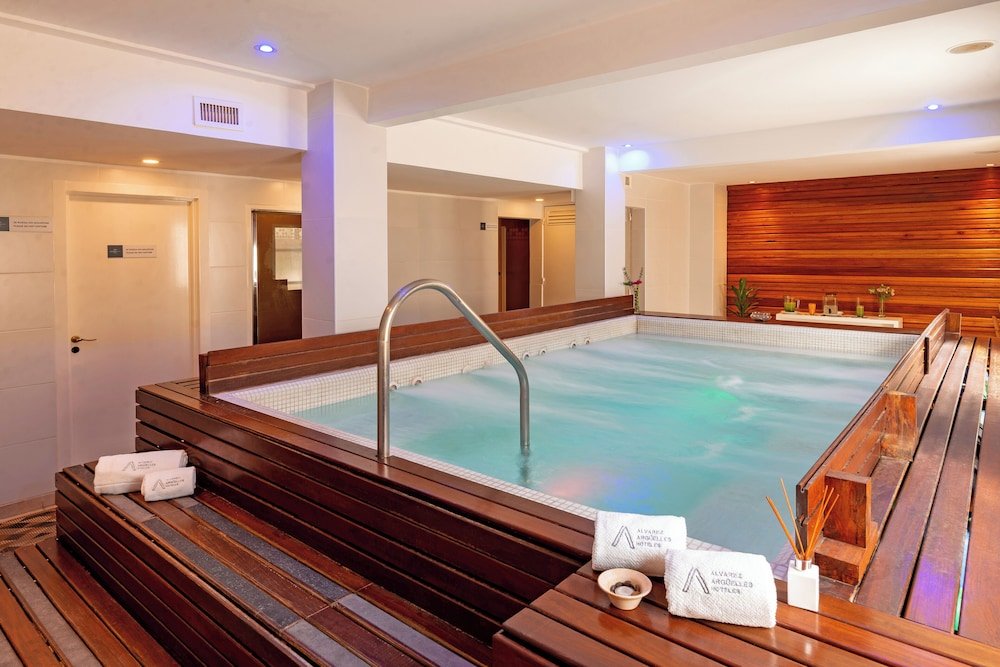 Sector del spa con banco de madera, jacuzzi y toallas