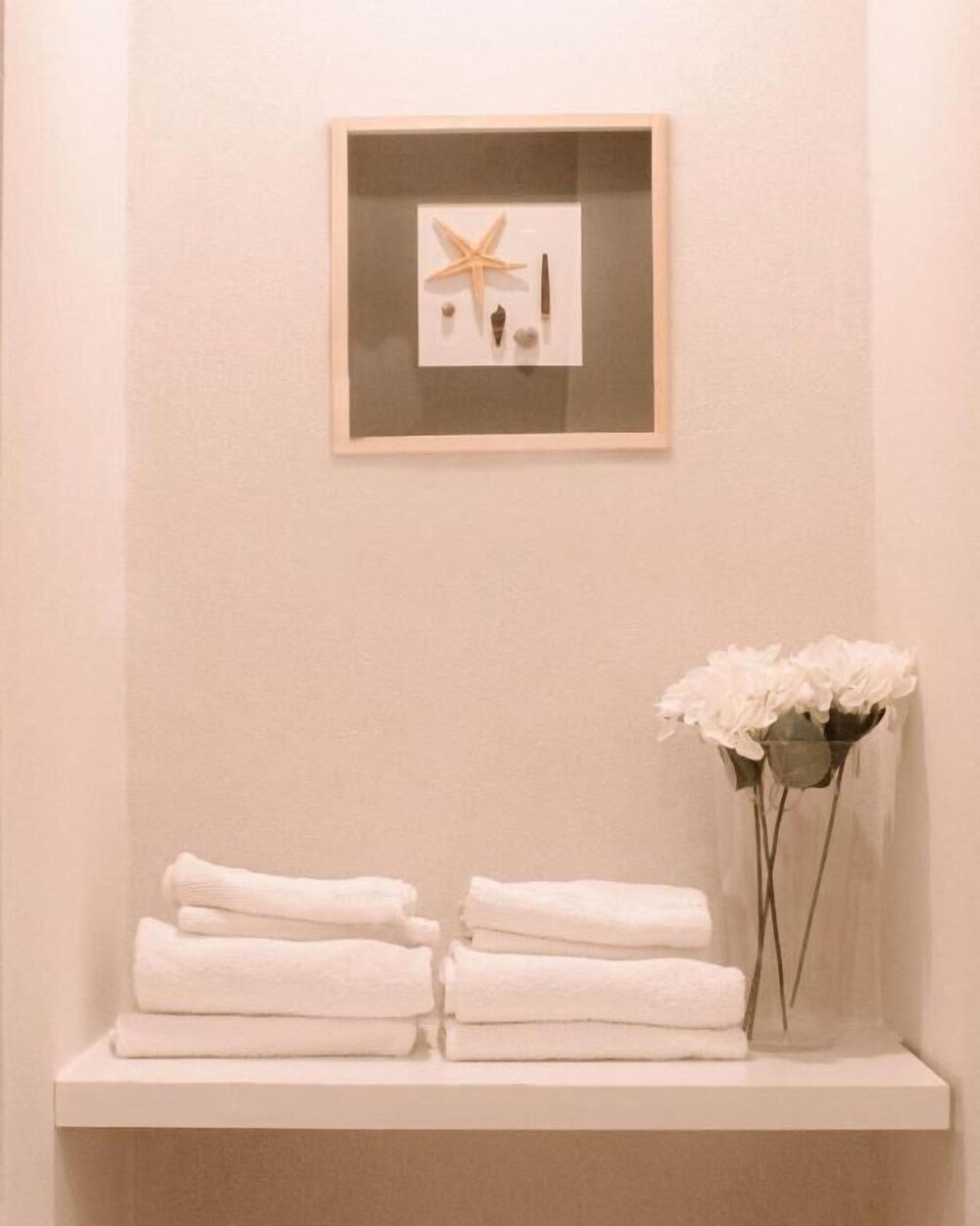 Baño decorado con una estrella de mar y flores blancas