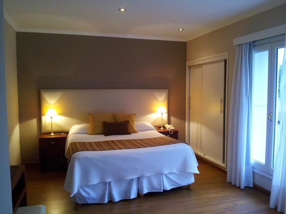 Habitación con cama grande, lámparas de mesa y puerta corrediza