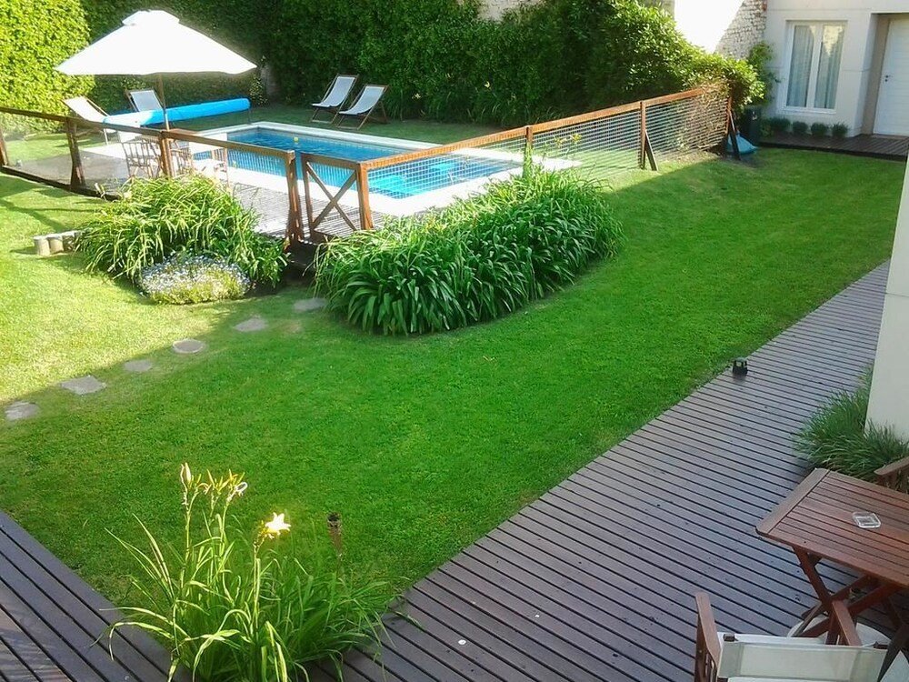 Patio trasero con pileta, reposeras y deck de madera
